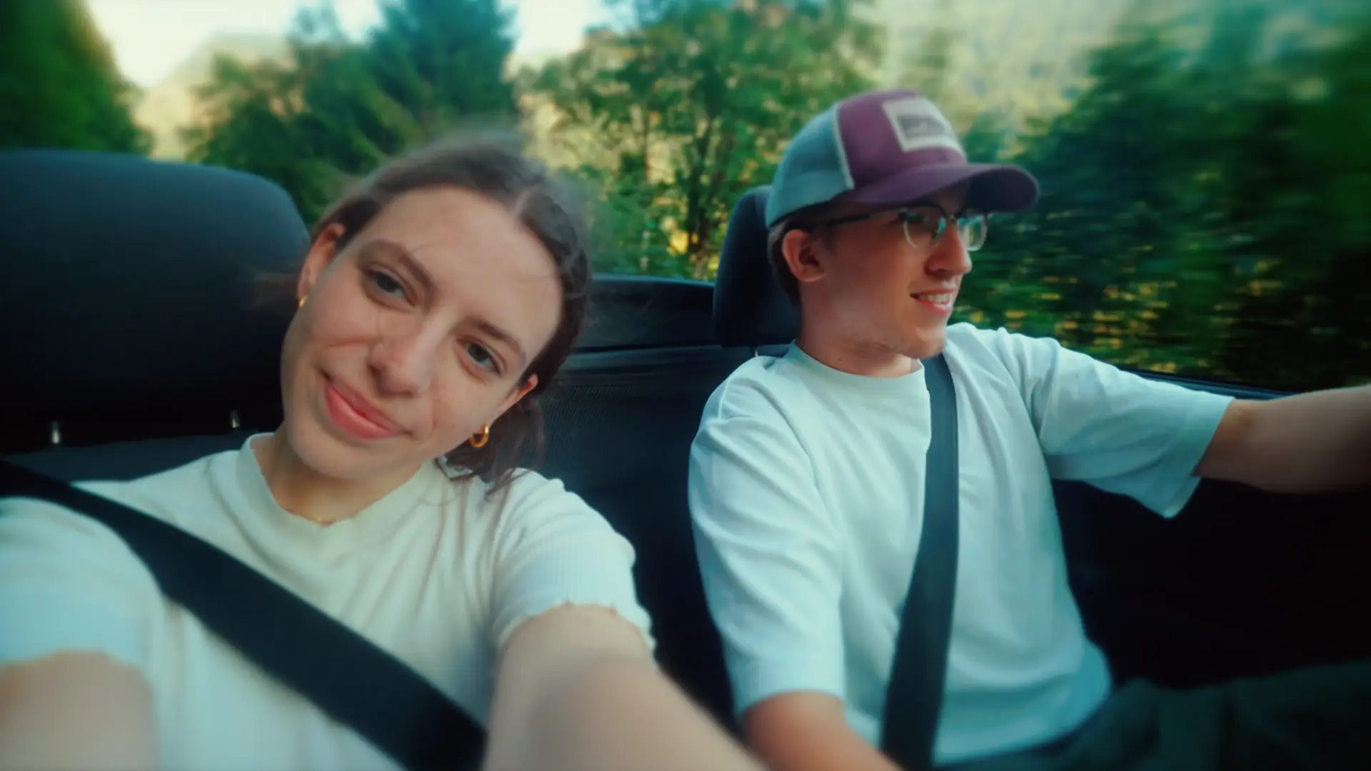 Couple driving a convertible through Austrian countryside