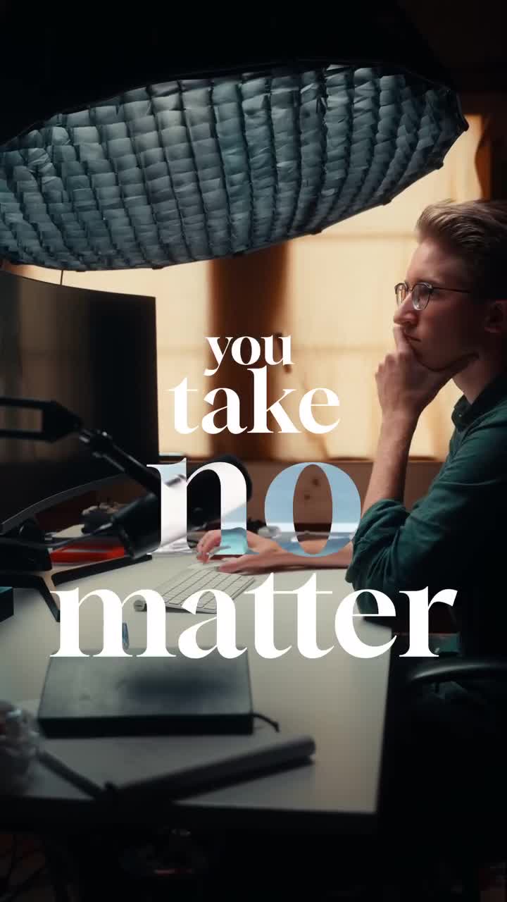 Creator working at a lit editing desk with a large softbox overhead in a vertical reel