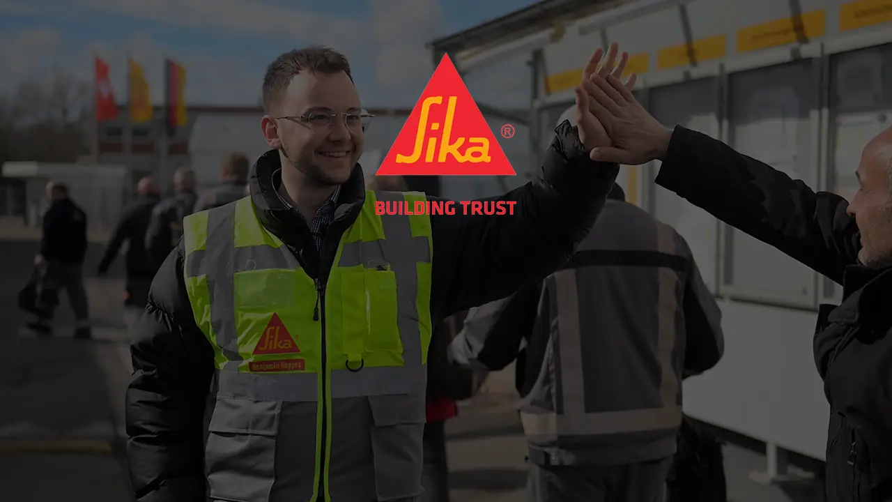 Sika employee in high-vis vest greeting colleagues at construction site