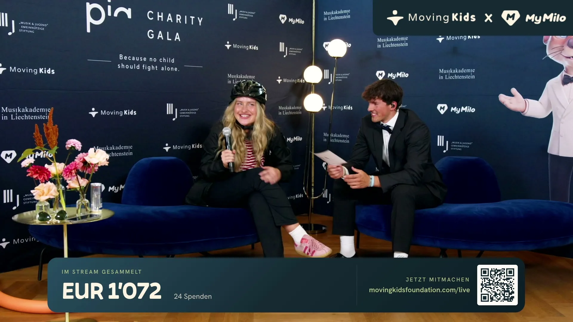 Ein Interview auf dem Sofa an der PIA Charity Gala, vor der Gala-Wand